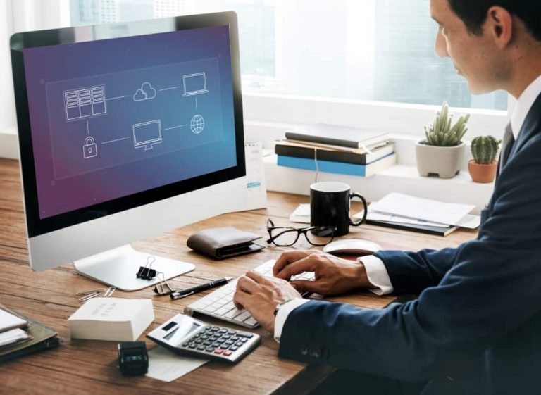 A business professional works at a desk with a computer.